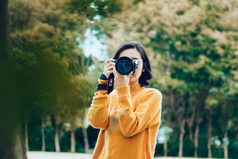 Beginner photographer reviewing camera settings — photography glossary of key terms explained