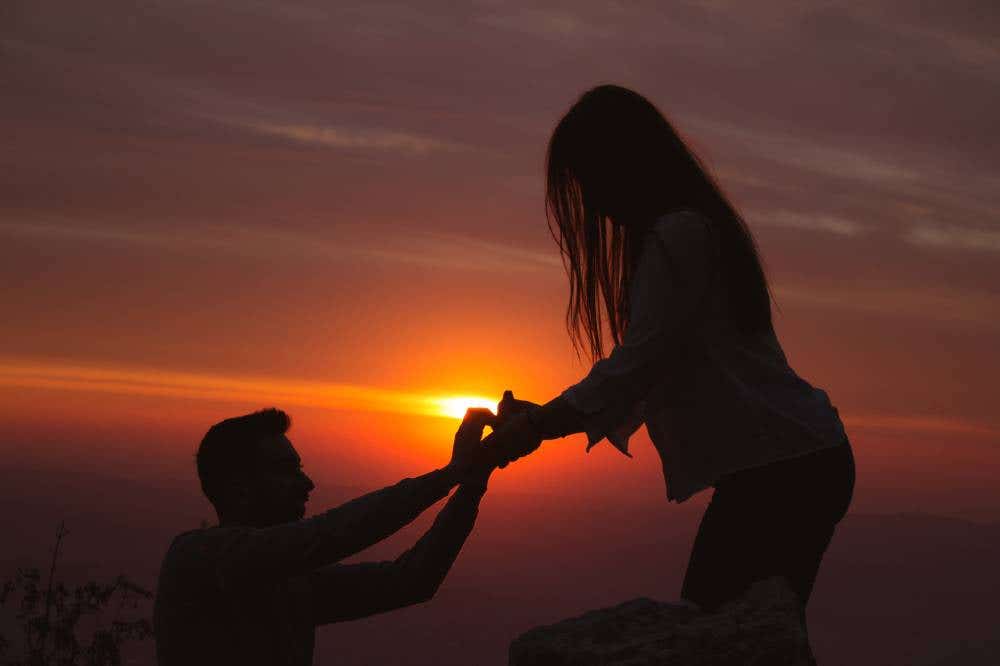 Couple at golden hour during a surprise proposal captured with a mirrorless camera on a tripod