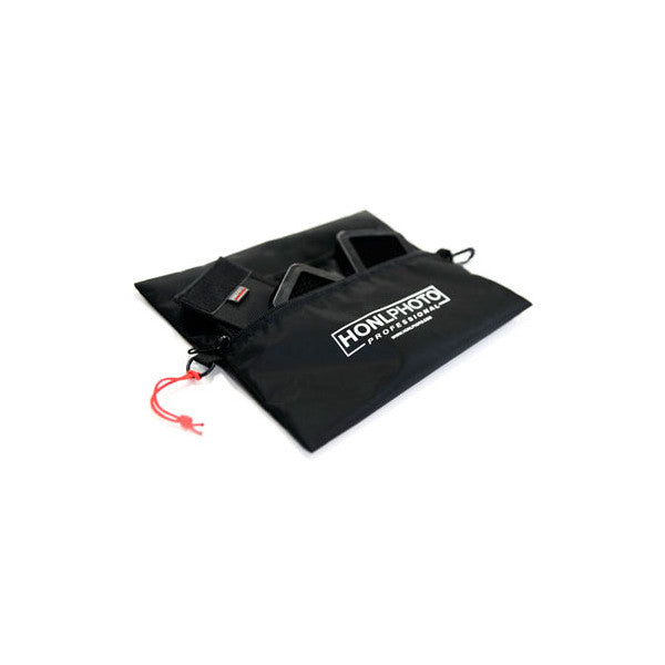 Black fabric carry bag for Honl Photo lighting system shown open from above, displaying interior compartments and red drawstring closure.