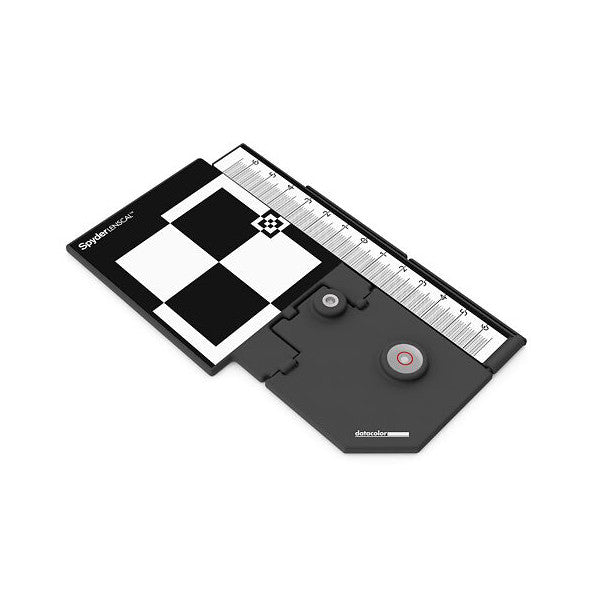 Angled top-down view of Datacolor SpyderLensCal focusing tool showing checkered calibration chart, measurement scale, and adjustment dials.