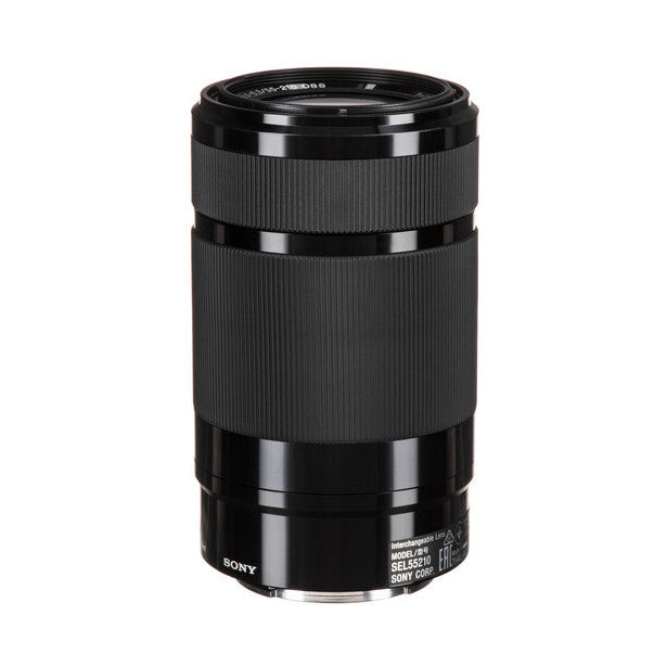 Black Sony E 55-210mm telephoto zoom lens shown at a three-quarter front angle against white background, displaying ribbed rubber focus ring and barrel.