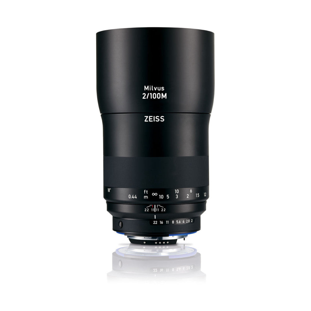 Black telephoto lens shown from front view against white background, displaying focus ring, aperture scale, and distance markings.