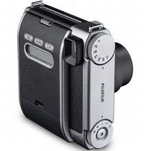 Fujifilm Instax Mini 99 silver instant camera shown from a three-quarter front view against a white background, displaying the lens and control buttons.