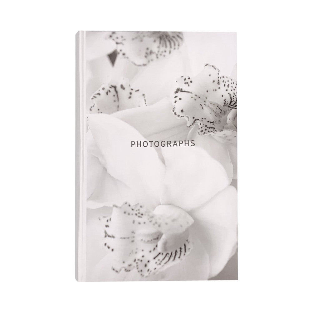 Front cover of white photo album featuring ethereal black and white image of orchid flowers with decorative beading details and "PHOTOGRAPHS" text centered.