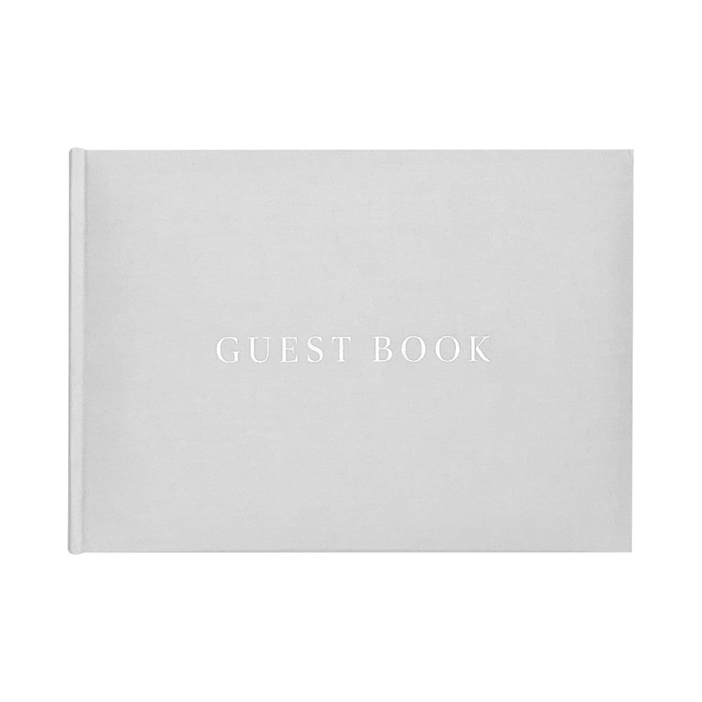 White hardcover guestbook displayed at an angle showing the front cover with "GUEST BOOK" text in silver lettering against a light gray background.