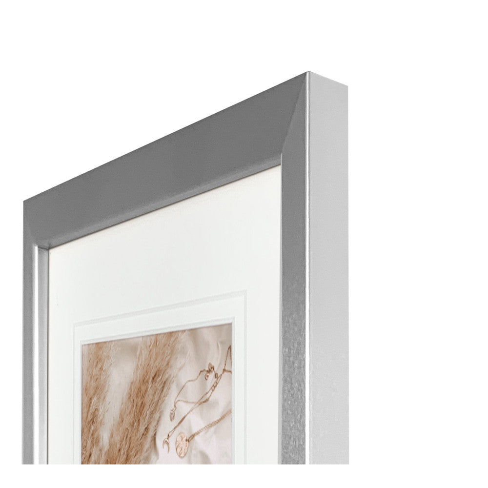 Angled view of a matt silver certificate frame with white matting and decorative artwork visible through the glass.