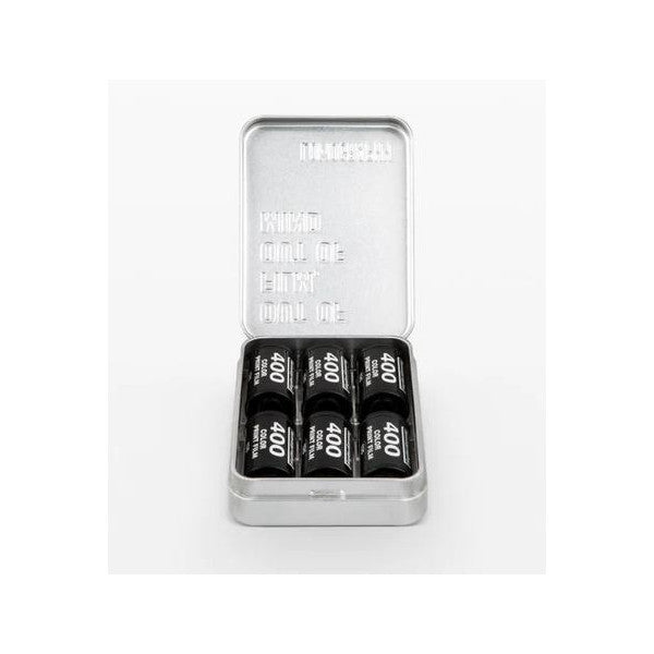 Open metal case displaying six black film canisters arranged in two rows inside, viewed from above against white background.