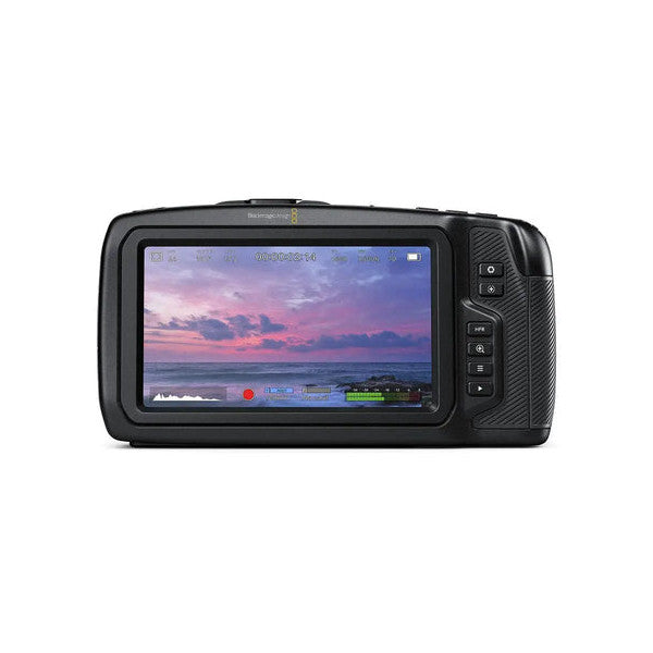 Blackmagic Pocket Cinema Camera 4K displayed at an angle, showing its rear LCD screen with a sunset video playing and control buttons on the right side.