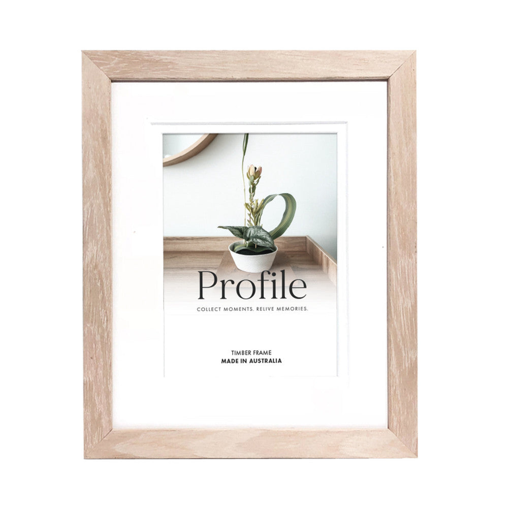 Front view of a natural timber photo frame with white matting, displaying a sample image of a potted plant with green leaf accent and "Profile" branding text.