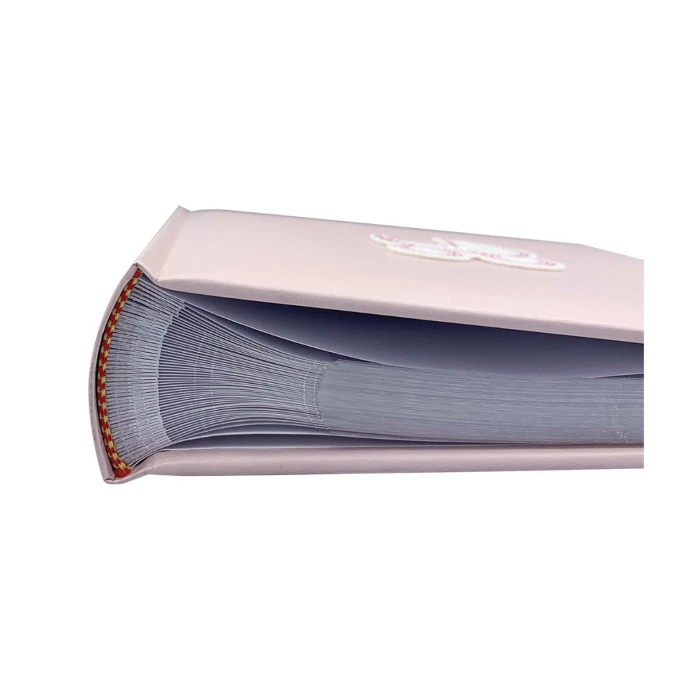 Close-up side view of an open pink photo album showing pages with red binding and blue-gray paper stock against white background.