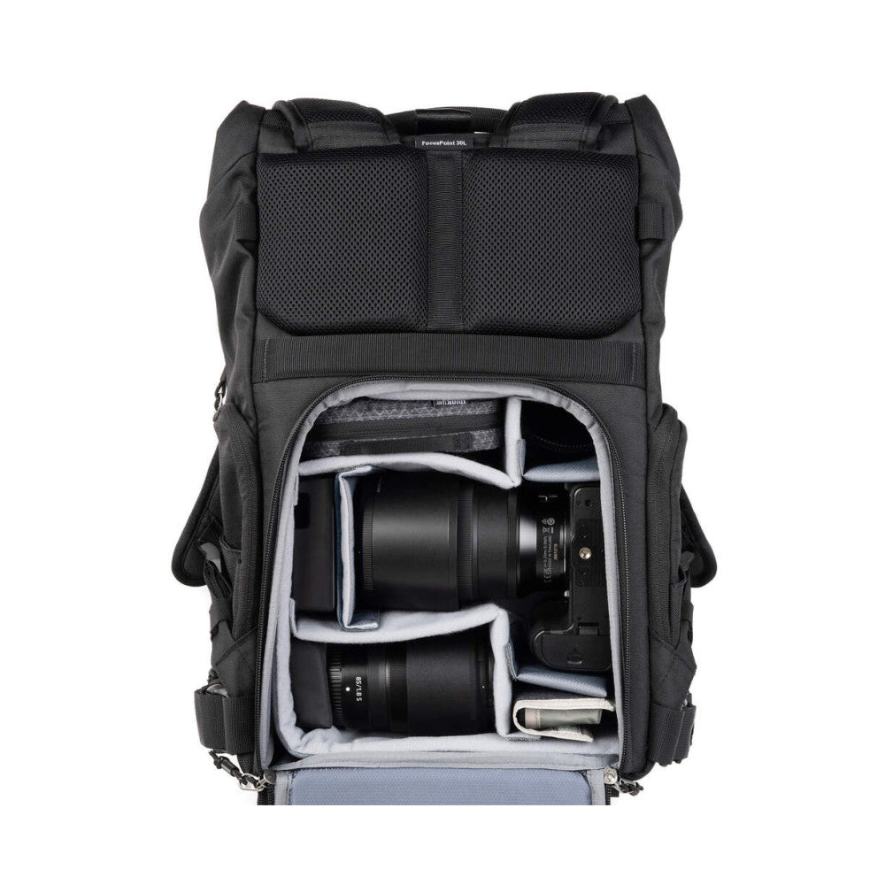 Front view of open black camera backpack showing interior compartments with camera body, lenses, and protective padding.
