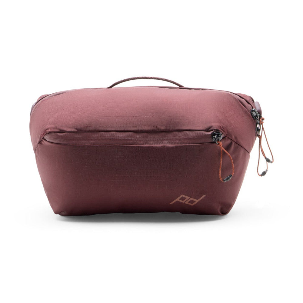 Burgundy sling bag shown from rear three-quarter view against white background, displaying back pocket and carry handle.