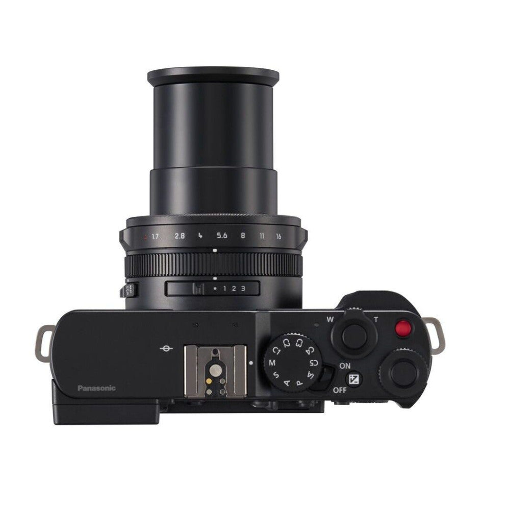 Top-down view of black Panasonic Lumix L10 camera showing lens, aperture ring, mode dial, and control buttons.