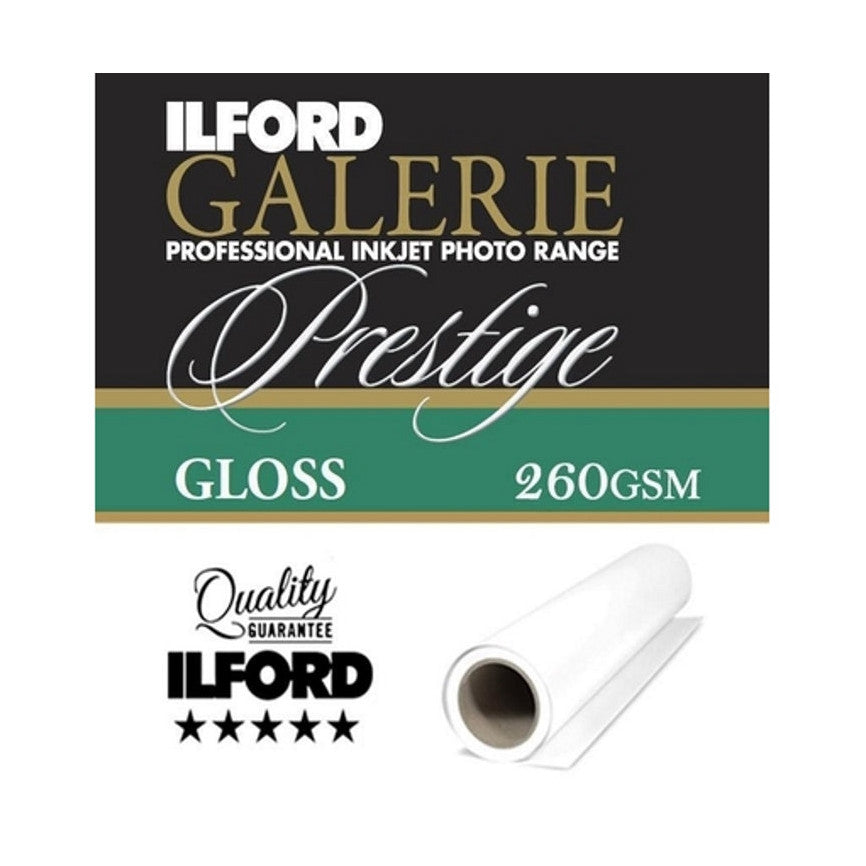 Product packaging and rolled paper sample displayed against dark background, showing Ilford branding, Prestige Gloss specification, and quality guarantee certification.
