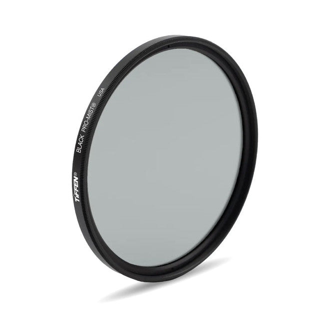 Angled product shot of a circular black camera filter with visible text on its rim, showing the glass surface at a slight tilt against a white background.