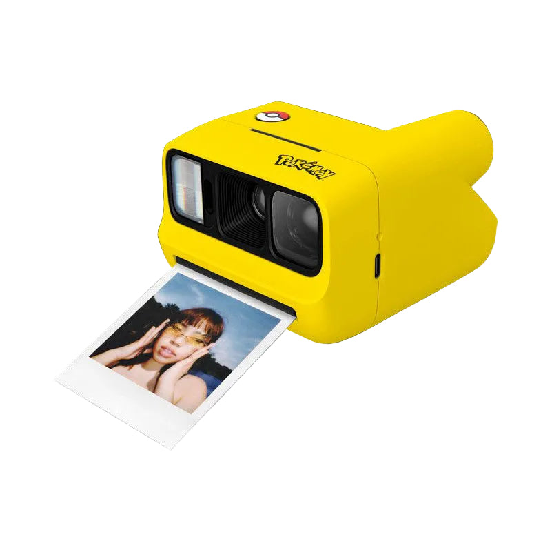 Bright yellow instant camera shown at an angle with a Polaroid photo ejecting from the front slot, displaying a portrait of a smiling person against a blue sky background.