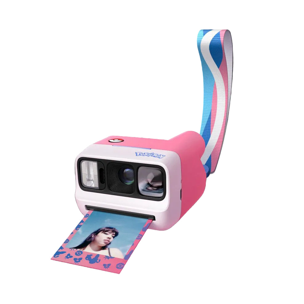 Pink and white Polaroid GO G3 camera with blue and pink strap, shown at an angle with an instant photo printing from the front slot.