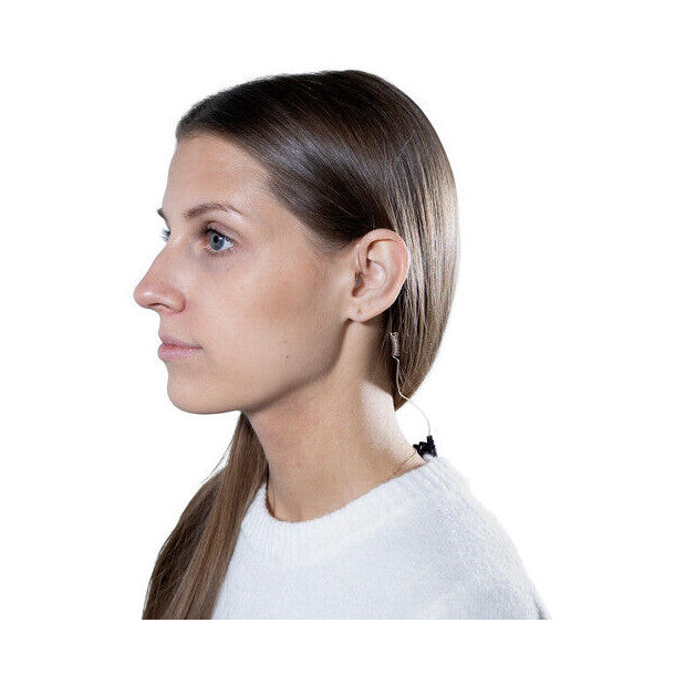 Woman wearing white shirt shown in profile view with black earpiece visible on ear and curly cable down neck