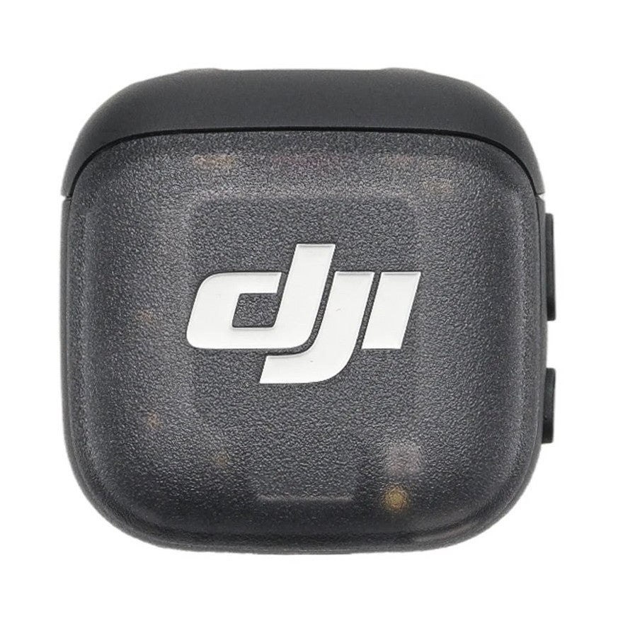 Top view of DJI MIC 3 TX Transmitter showing white DJI logo on dark textured surface with rounded edges
