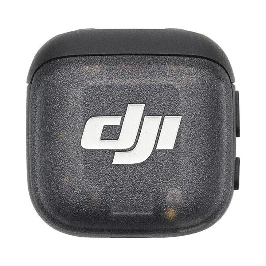 DJI MIC 3 TX transmitter shown from front view, displaying the white DJI logo on dark gray textured surface against white background.