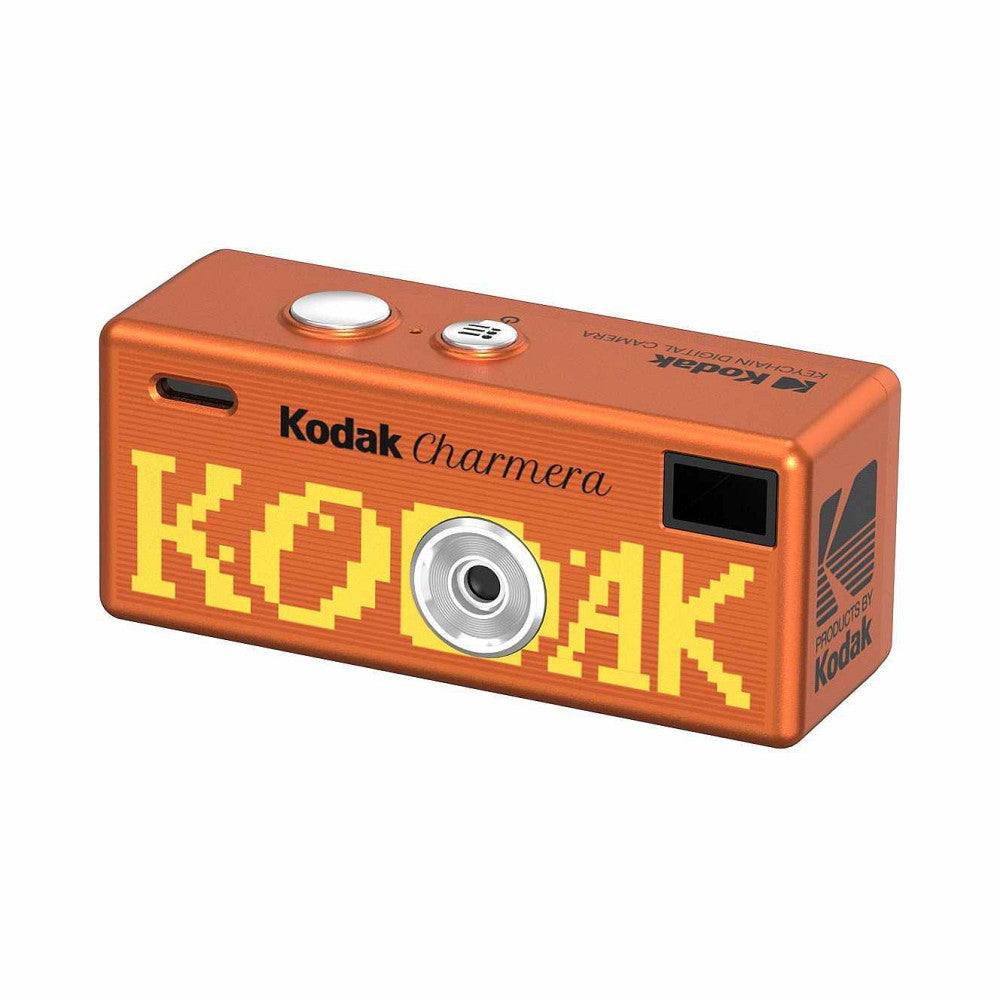 Orange rectangular miniature digital camera with yellow pixelated "KODAK" text, small lens in center, and control buttons on top, shown at three-quarter angle against white background.