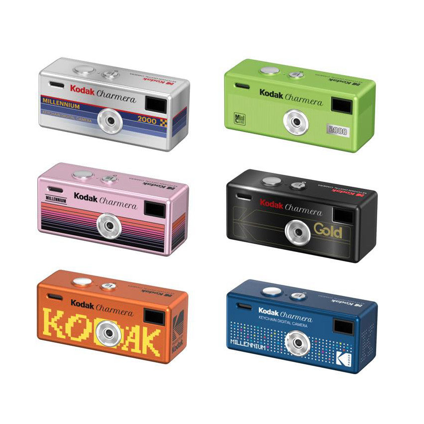 Six colorful Kodak Charmera Millennium keychain digital cameras displayed at angles, showing their compact rectangular design in silver, green, pink, black, orange, and blue finishes.