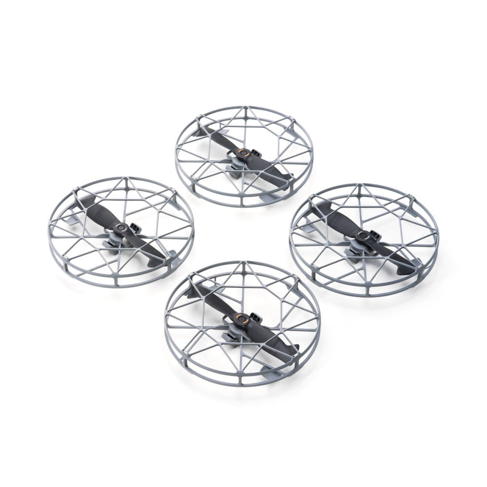 Four DJI Mini 5 Pro drones with protective propeller guards arranged in a circular pattern against a white background, overhead view.