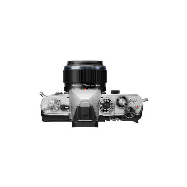 Top-down view of silver OM System OM-3 mirrorless camera with black 17mm f1.8 lens mounted, showing controls and dials.
