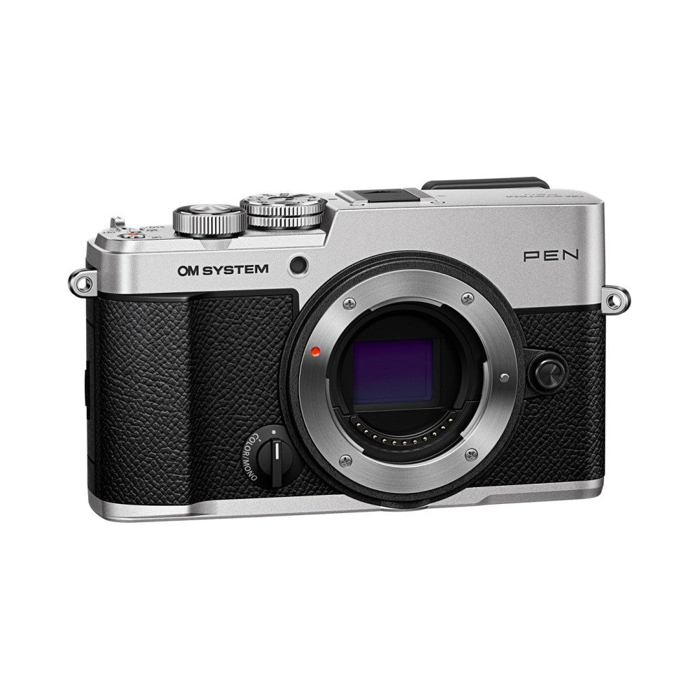 Front three-quarter view of a silver and black mirrorless camera with textured grip, showing the open lens mount and control dials.
