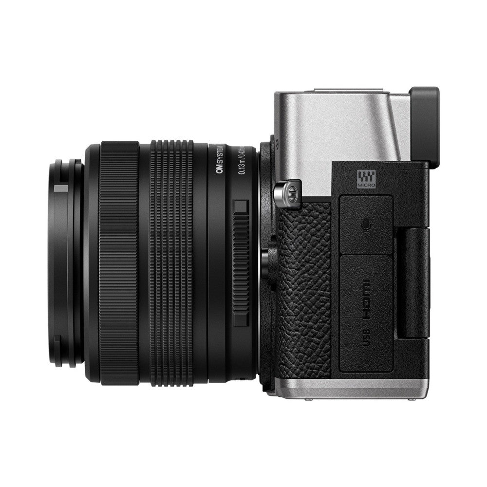 Side view of silver OM System PEN camera with attached black zoom lens, showing grip, controls, and viewfinder against white background.