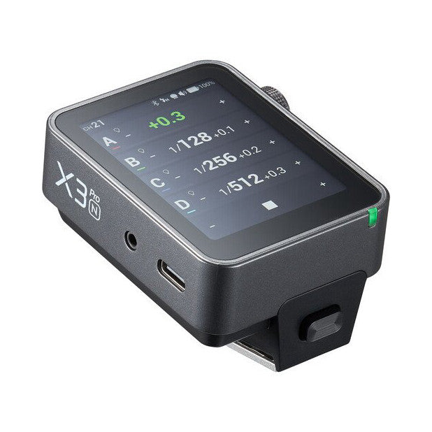 Godox X3 PRO wireless flash trigger shown at angle displaying touchscreen with camera settings and flash information, with ports visible on side.