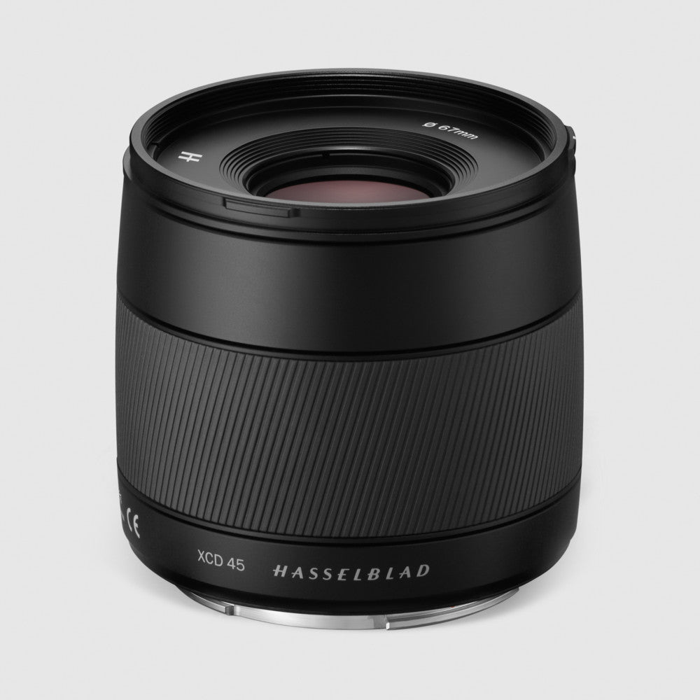 Black Hasselblad XCD 45mm f/3.5 lens displayed against gray background, front three-quarter view showing barrel and front element.