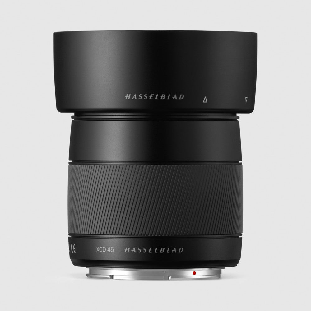 Black Hasselblad XCD 45mm lens shown from front angle against gray background, displaying barrel, focus ring, and mount.