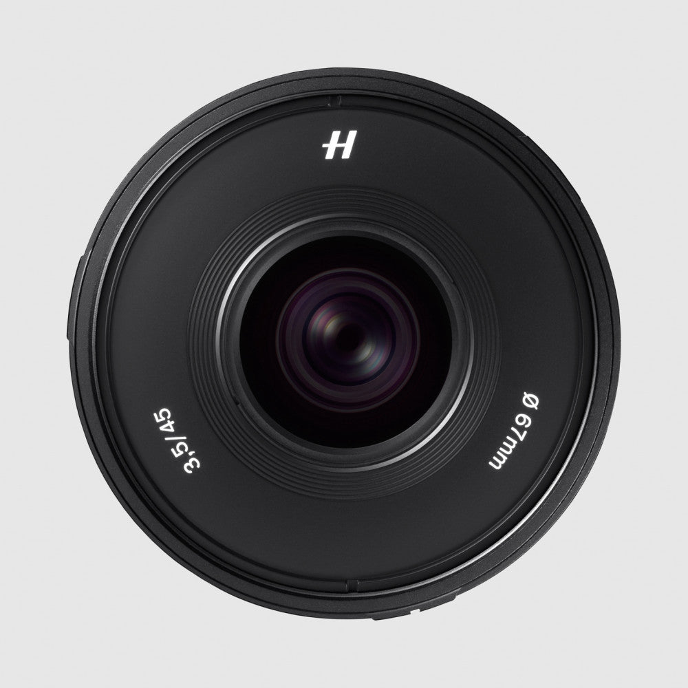 Front view of a black Hasselblad XCD 45mm f/3.5 lens showing the glass element and barrel markings against a light gray background.