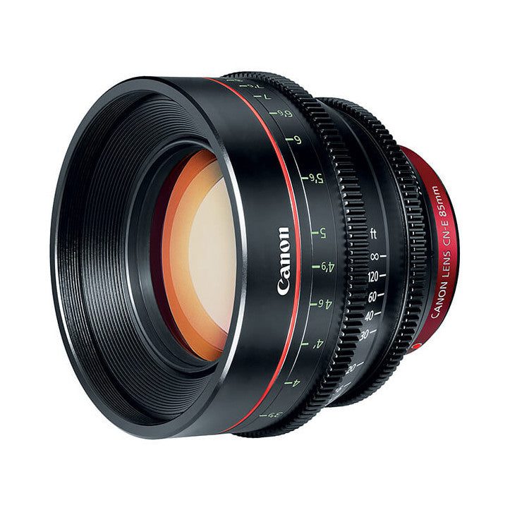 Canon CN-E 85mm T1.3 cinema lens shown at angle, displaying front element, focus ring markings, and red lens barrel detail.