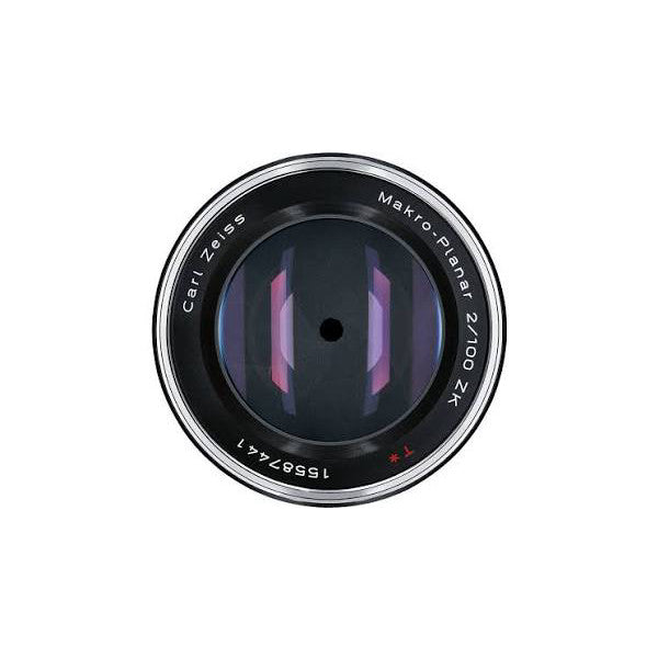Front view of Zeiss 100mm Makro-Planar ZF.2 lens showing glass elements and aperture blades through the optical assembly.