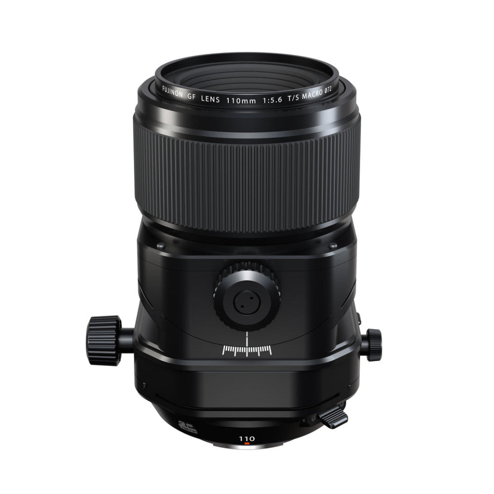 Front view of a black Fujifilm GF 110mm macro lens with ribbed focusing ring and tilt-shift control mechanism visible against a white background.