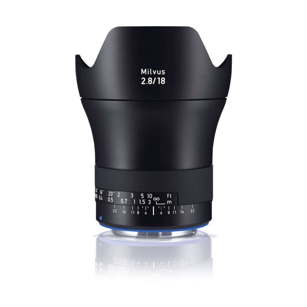 Black Zeiss Milvus 18mm f/2.8 lens shown front view with lens hood extended, displaying focus ring and distance scale markings.