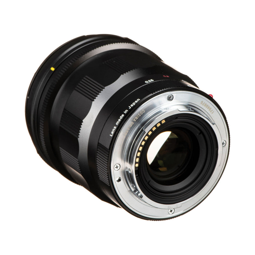 Rear three-quarter view of a black Voigtländer Nokton 21mm f/1.4 lens showing the mount contacts and rear element against white background.