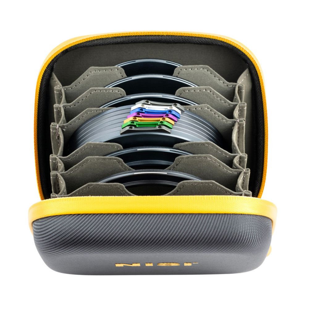 Top-down view of open yellow camera filter case revealing organized stack of circular ND and CPL filters with colored metal frames in compartments.
