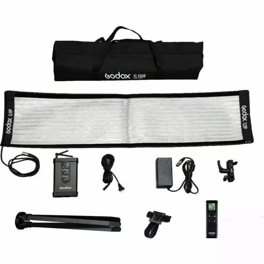 Flat lay product display of Godox FL150R LED panel with carrying bag, controller, power adapter, remote, stand, and accessories arranged on white background.