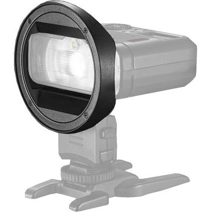 Black circular adapter ring mounted on camera flash mount, shown at three-quarter angle against white background.