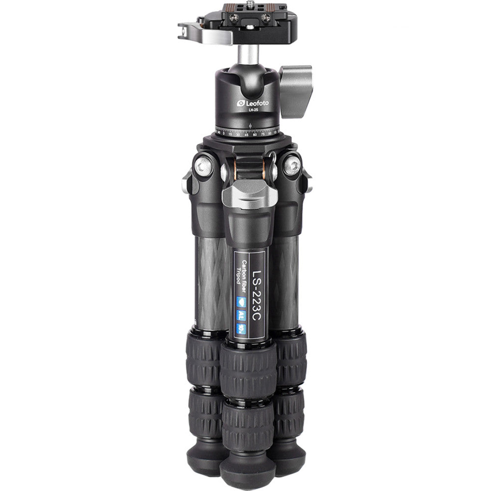 Front view of a black carbon fiber tripod with extended legs, ball head mounted on top, and adjustment knobs visible on the sides against a white background.