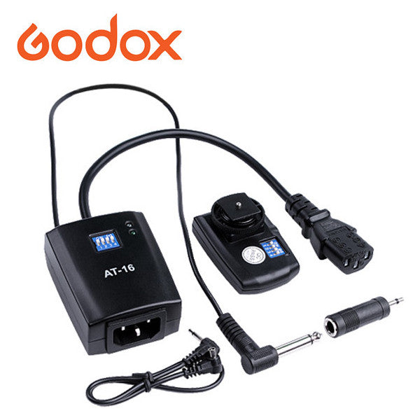 Godox AT-16 wireless trigger kit components displayed flat lay showing receiver, transmitter, power adapter, and sync cables against white background.