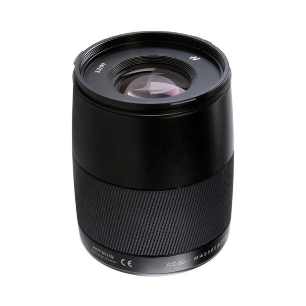 Black Hasselblad XCD 90mm lens photographed against white background, showing front element and barrel with focus ring detail.