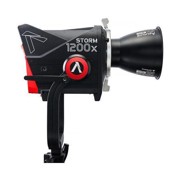 Side view of Aputure Storm 1200X LED light showing black body with red accents, reflector attachment, and cable management system against white background.