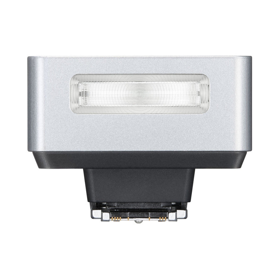 Top-down view of a silver and black compact camera flash unit showing the rectangular lens element and connection contacts.