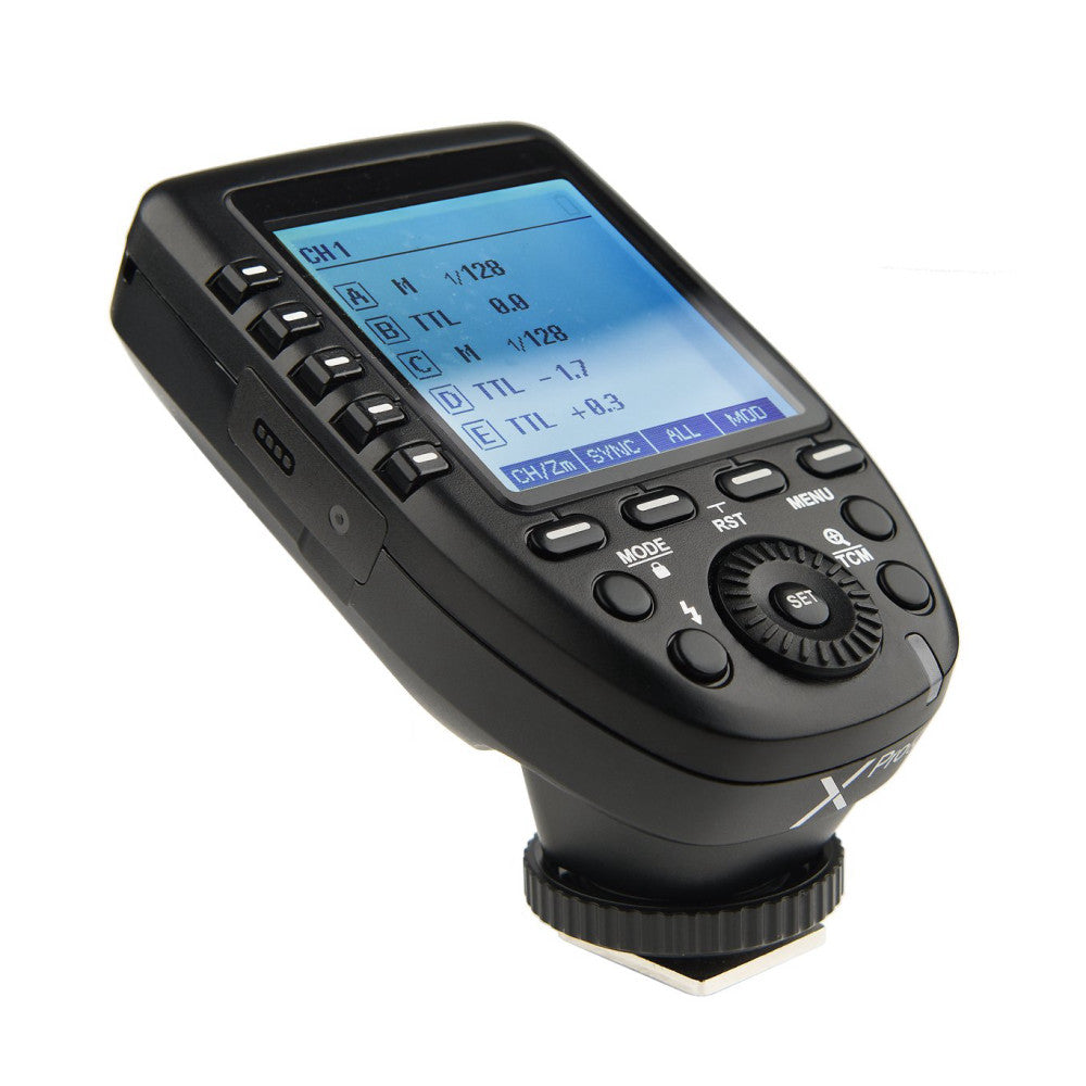 Black wireless flash trigger with LCD screen displaying TTL settings, shown from angled front view against white background.