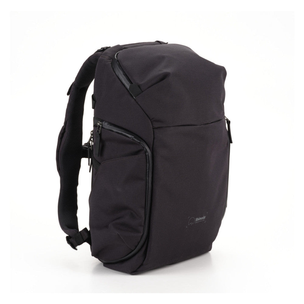 Black backpack photographed from the front-left angle, displaying the main compartment, side pocket with zipper, and padded shoulder strap against a white background.
