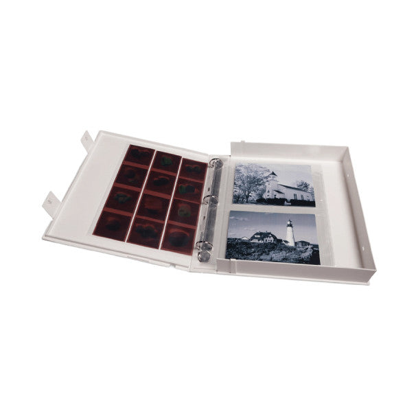 Open white binder showing archival slide pages on left and black and white photographs on right, with metal O-ring binding visible.